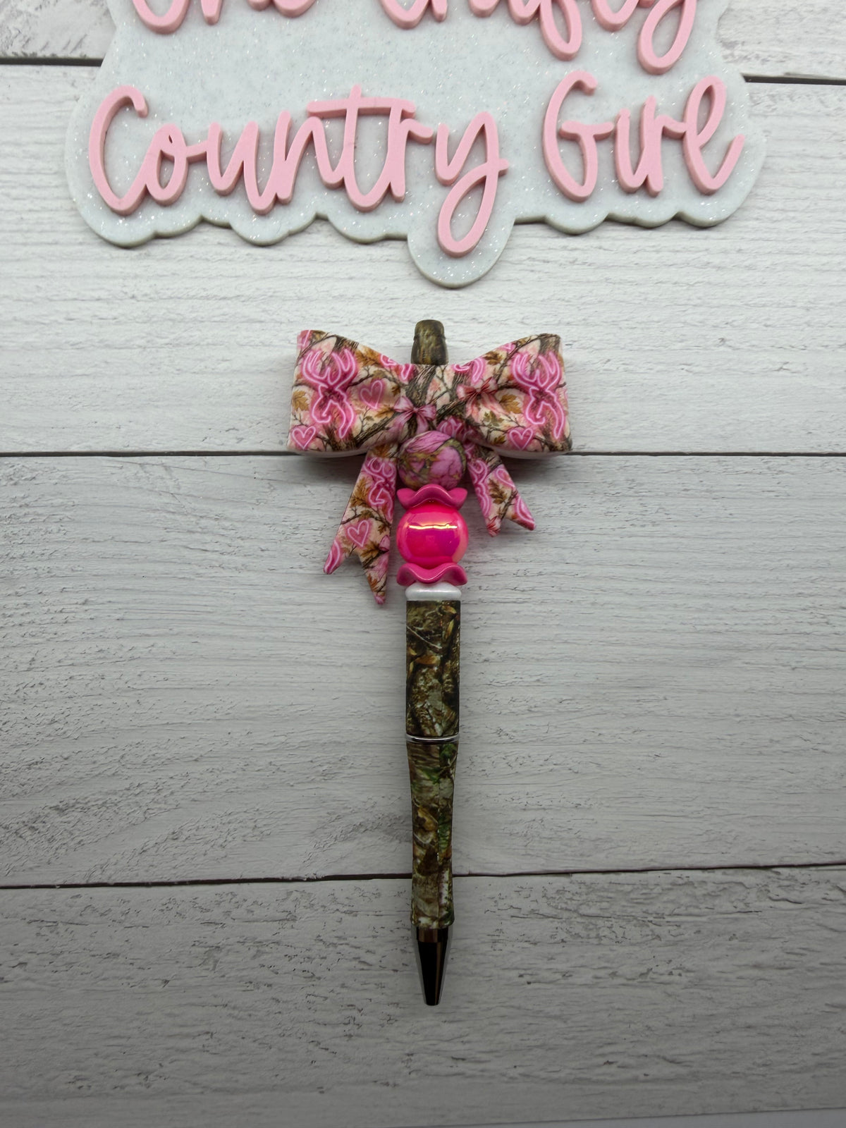 Pink deer camo bow on a camo pen