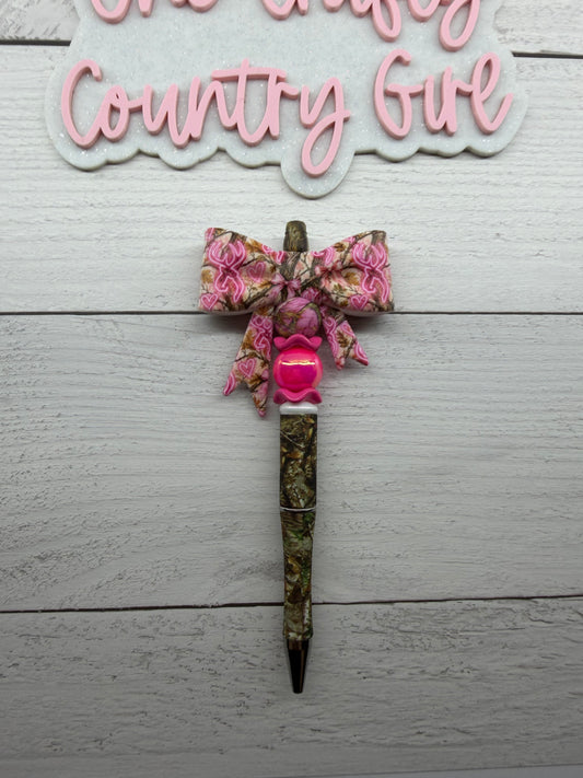 Pink deer camo bow on a camo pen